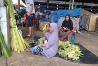 Seorang Ibu Rumah Tangga Zam Zam memperlihatkan ketupat yang di belinya di Pasar MMTC Jalan Pancing Medan